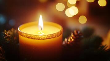A Single Lit Candle with Golden Bokeh Lights and Evergreen Sprigs photo