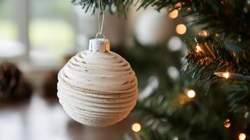 White, Circular, Layered Christmas Ornament Hanging on a Tree photo