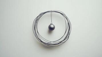 A single silver Christmas ornament hanging from a wire wreath against a white background photo