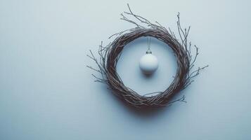 A Simple White Ornament Hanging from a Twig Wreath photo