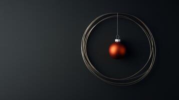 An Orange Christmas Ornament Hanging in a Gold Circle on a Black Background photo