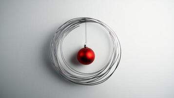 A Red Christmas Ornament Hanging Within a Silver Wire Circle photo