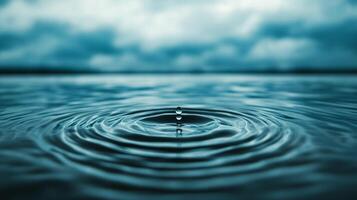 Close up of raindrop ripples on a calm lake surface under a cloudy sky photo