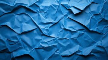 Crinkled blue paper background with deep creases and shadows creating a textured worn effect photo