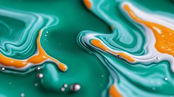Macro image of liquid paint waves mixing turquoise and orange with marbled patterns photo