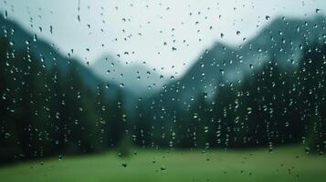 Raindrops on a fogged window with a distant mountain landscape barely visible in the background photo