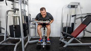 A Caucasian man intensely working out on a back extension machine in a gym, emphasizing fitness goals and challenges photo