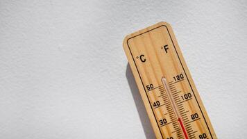 Wooden thermometer showing high temperature, symbolizing heatwaves, climate change, and summer weather issues photo