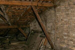 Old, cluttered attic with wooden beams and brick walls, perfect for concepts of disorganization, storage challenges, or Halloween photo