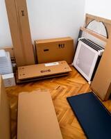 Various flatpack furniture boxes ready for assembly in a home, representing DIY challenges and the concept of home improvement photo