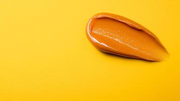 Burnt sienna lip balm smear with soft gloss texture isolated on a soft gradient of mustard yellow photo