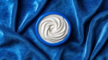 Creamy pearl white facial mask with hints of silver sparkles softly spread on a deep blue velvet background photo