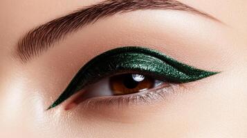 Deep emerald green eyeliner stroke with a metallic sheen sharp edges contrasting against a light beige background photo