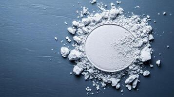 Frosty silver eyeshadow powder finely scattered on a cool grey surface resembling a winter frost pattern photo