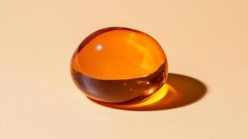 Glossy caramel lip gloss in a thick luminous droplet with highlights catching warm light on a creamy background photo