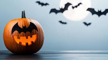 Halloween pumpkin carved with a bat silhouette with real bats flying in the background under a full moon photo