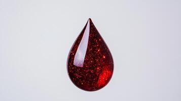 Macro of fine red and gold cosmetic pigments floating in clear serum suspended in a transparent drop against white photo