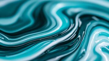 Macro shot of swirling blue and green marbled nail polish blending into fluid abstract waves with a glossy finish photo