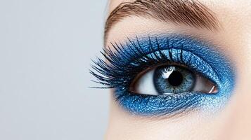 Metallic frosted blue eyeliner stroke against a smooth matte white background resembling a winter sky photo