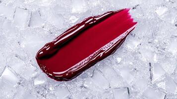Rich velvety plum lipstick smear with a matte finish against a frosty silver background evoking winter elegance photo