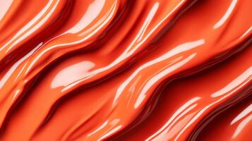 Swirls of rich coppery red liquid lipstick creating an abstract pattern on a soft muted orange background photo