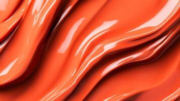 Swirls of rich coppery red liquid lipstick creating an abstract pattern on a soft muted orange background photo