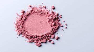 Warm blush powder in a soft muted mauve shade lightly dusted on a pale grey background photo