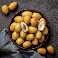 Overhead view of Fresh, Pile, Ripe and juicy sweet yellow date palm. Halves food summer background photo