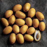 Overhead view of Fresh, Pile, Ripe and juicy sweet yellow date palm. Halves food summer background photo