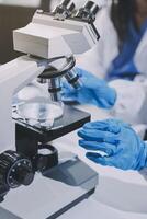 Scientist using microscope in laboratory. Close-up of a researcher's hands adjusting a modern microscope in a lab setting. Science concept photo