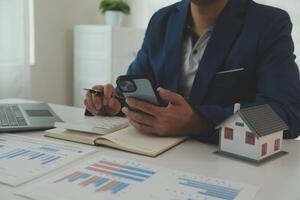 Businessmen holding pens, signing home titles with insurance, care about real estate services and the idea of real estate agents offering interest in installments to their customers. photo
