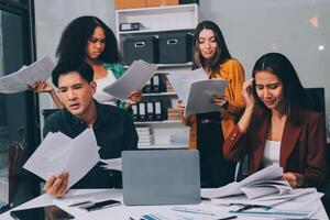 Stress, business people and employee frustrated with multitasking, pressure or overworked by team in chaos with paperwork. Anxiety, headache and worker overwhelmed by group and burnout in crisis photo