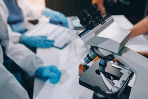 Scientist using microscope in laboratory. Close-up of a researcher's hands adjusting a modern microscope in a lab setting. Science concept photo