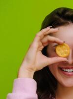 Young woman holding salty cracker in front of her eye smiling photo