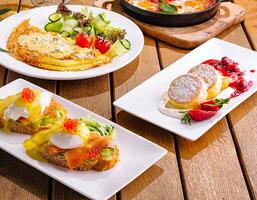 omelet with salad and cottage cheese pancakes and avocado toast and eggs benedict photo