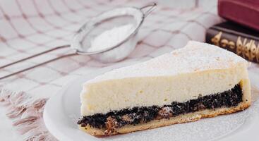 Slice of poppy seed cake with cottage cheese filling sitting on white plate photo