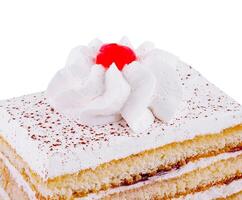 Delicious slice of layered cake with whipped cream and cherry topping on white background photo