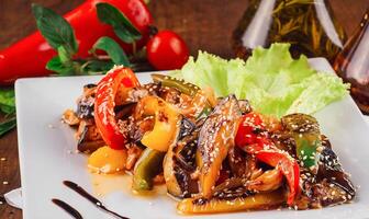 Delicious grilled vegetables with chicken and sesame seeds on white plate photo