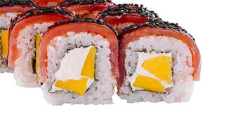 Sushi rolls with mango and cream cheese filling are covered with red fish and black sesame seeds photo