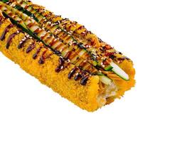 Tempura sushi roll topped with cucumber and sesame seeds on white background photo