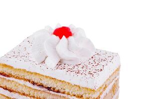 Delicious cake topped with whipped cream and cherry is being served photo