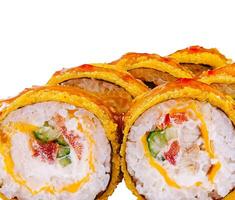 Tempura maki sushi rolls covered with nuts and sauce lying on white background photo