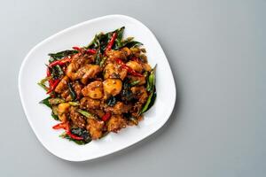 Ayam Tangkap, spices fried chicken original from Aceh, Indonesia. served with leaves such as temurui or curry leaves, pandan leaves and green chili, that are roughly chopped and fried crispy. photo