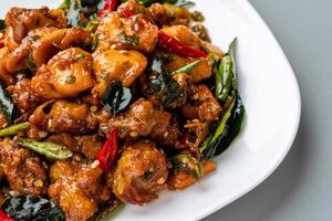 Ayam Tangkap, spices fried chicken original from Aceh, Indonesia. served with leaves such as temurui or curry leaves, pandan leaves and green chili, that are roughly chopped and fried crispy. photo