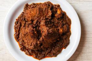Beef Rendang is a Minang dish originating from the Minangkabau region in West Sumatra, Indonesia. Rendang has been slow cooked and braised in a coconut milk seasoned with a herb and spice mixture photo