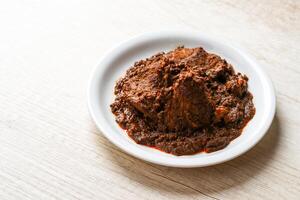 Beef Rendang is a Minang dish originating from the Minangkabau region in West Sumatra, Indonesia. Rendang has been slow cooked and braised in a coconut milk seasoned with a herb and spice mixture photo