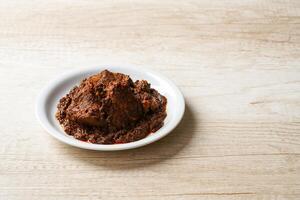 Beef Rendang is a Minang dish originating from the Minangkabau region in West Sumatra, Indonesia. Rendang has been slow cooked and braised in a coconut milk seasoned with a herb and spice mixture photo