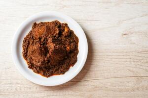 Beef Rendang is a Minang dish originating from the Minangkabau region in West Sumatra, Indonesia. Rendang has been slow cooked and braised in a coconut milk seasoned with a herb and spice mixture photo