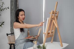 Young Woman Drawing on Canvas in Modern Room, Relaxing and Creating Art in a Comfortable Home Environment photo