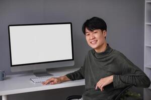 Young Boy Studying Online at Home with Computer, Engaged in E-Learning and Remote Education, Smiling and Sitting at Desk photo